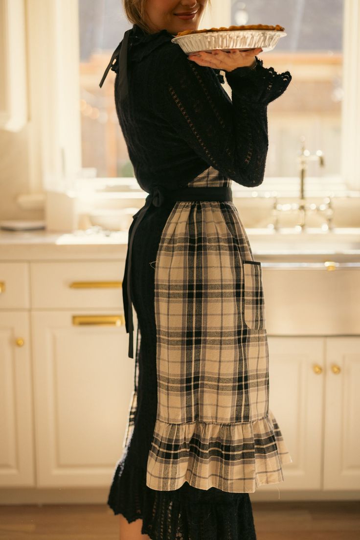 Be the ultimate kitchen fashionista with our Ivy Apron in Laura Plaid Cotton. Featuring a darling black and white plaid print, with a functional square neckline and waist ties, as well as a midi-length skirt with pockets and a charming ruffle hem. This apron makes cooking stylish and convenient. Don't just cook, make a statement in this 100% cotton beauty! Cute Baker Outfit, Baker Outfit Aesthetic, Cooking Outfit, Baker Outfit, Box Noel, Apron Skirt, Ruffle Apron, Pinafore Apron, White Bridal Dresses