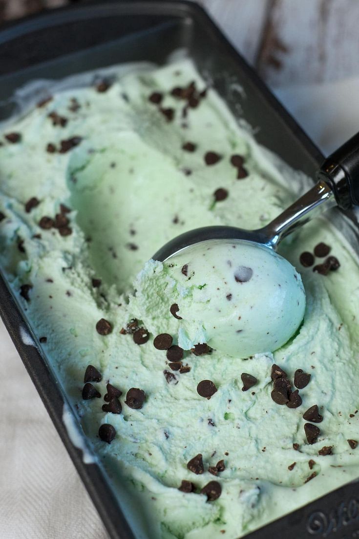 a scoop of ice cream with chocolate chips on top in a metal pan, ready to be eaten