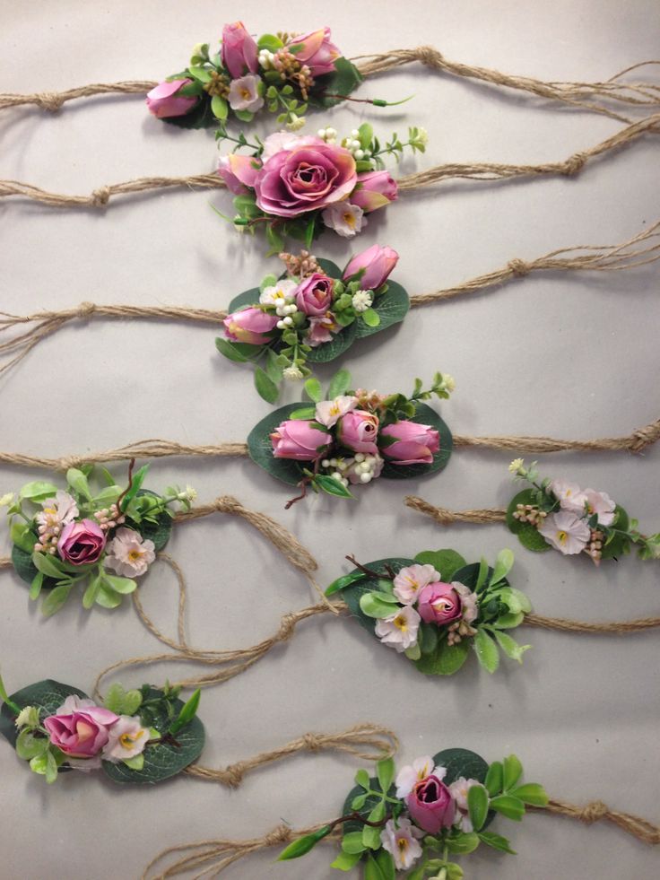 there are many different flowers on the wall with some rope attached to each flower headband