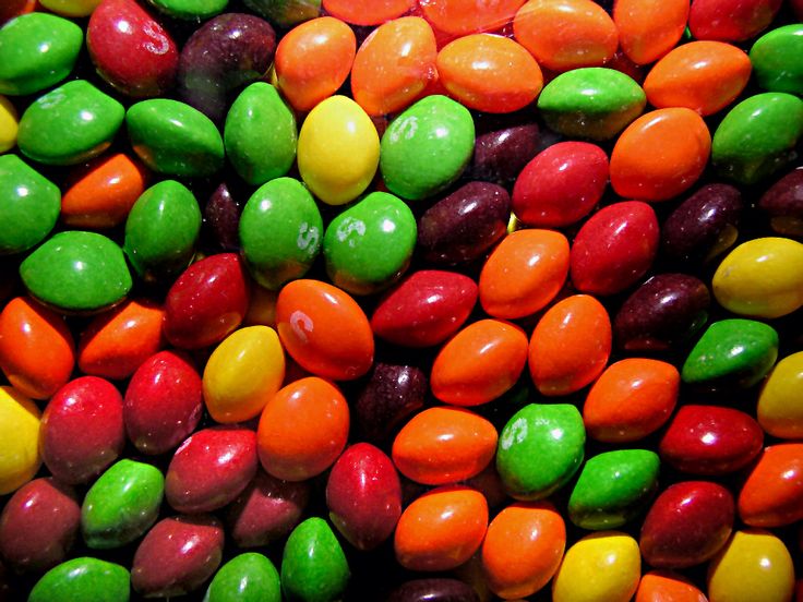 there are many different colored candies in the bowl