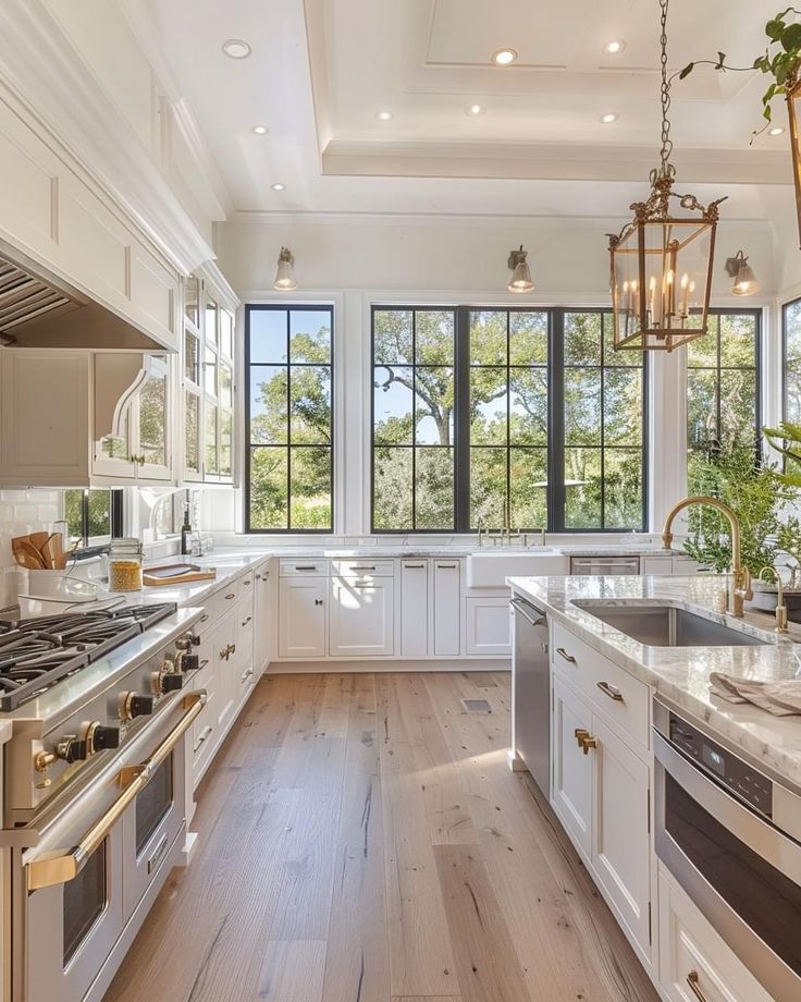 a large kitchen with white cabinets and wood floors