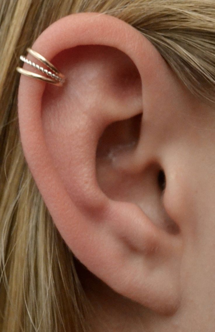 a close up of a person's ear with two thin rings