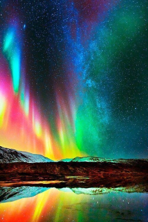 an aurora bore is reflected in the water and it's lights are glowing brightly