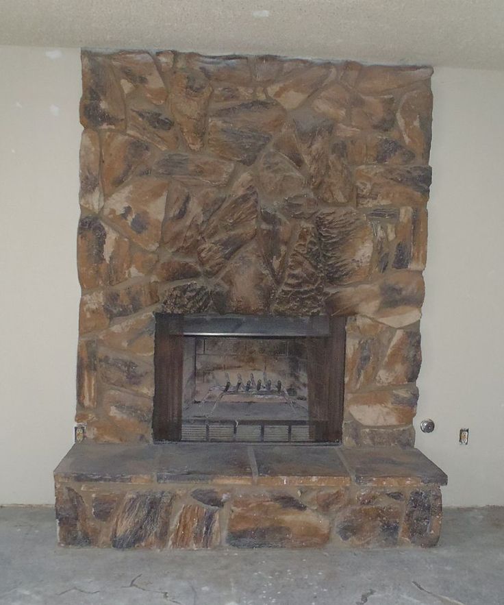 a stone fireplace is shown in the corner of a room with no one around it