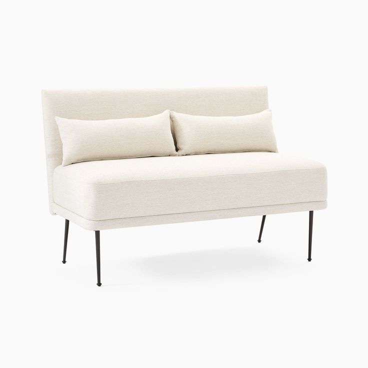 a white couch with two pillows on it's back and one arm folded up