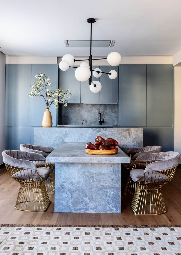 an image of a kitchen setting with blue walls and furniture in the center, including chairs