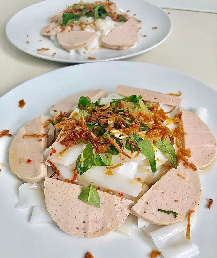 two white plates topped with food on top of a table