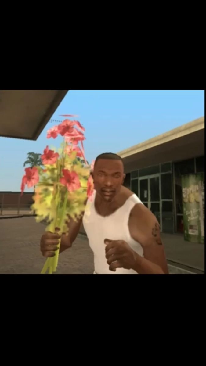 a man holding flowers in front of a gas station