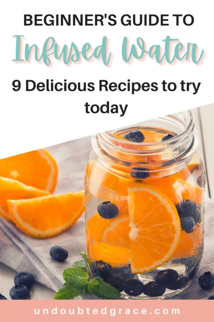 a mason jar filled with orange slices and blueberries on top of a cloth next to a