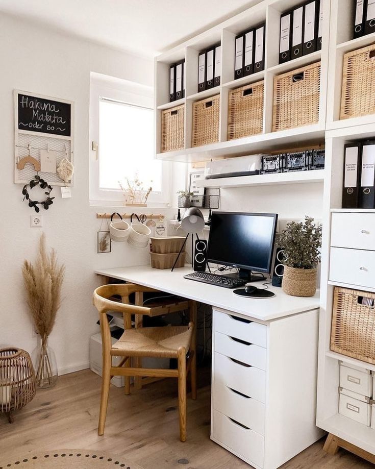 a desk with a computer on top of it in front of some baskets and other items