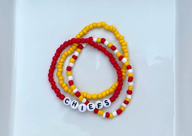 three beaded bracelets with the word cheer written on them