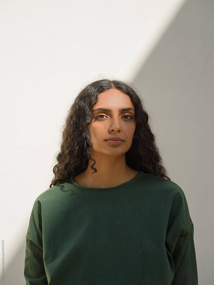 a woman standing in front of a white wall