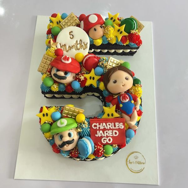 a birthday cake for a child's 5th birthday with mario and luigi on it