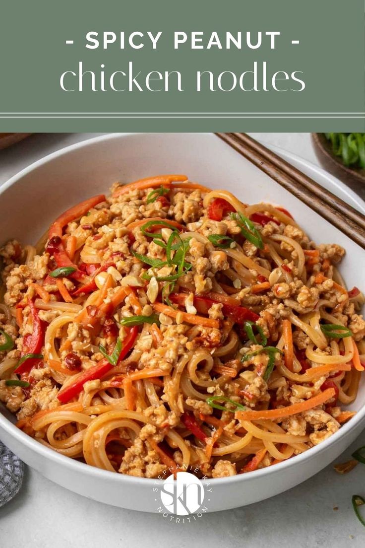 a white bowl filled with noodles and meat on top of a table next to chopsticks