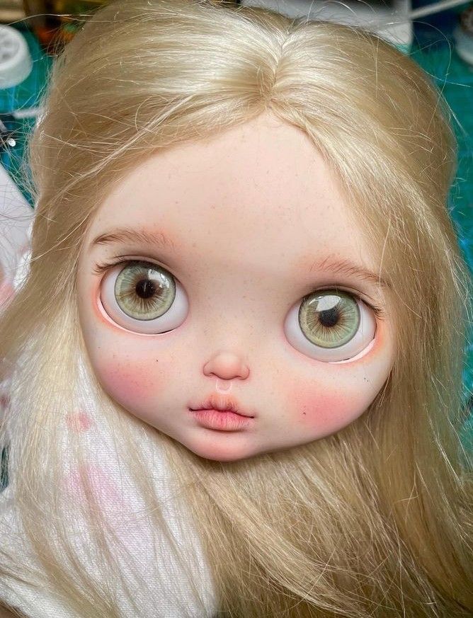 a doll with long blonde hair and big eyes