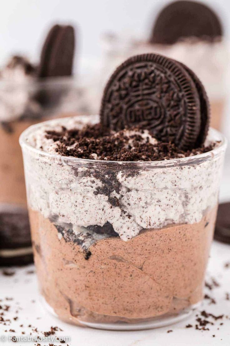 an oreo cookie dessert in a glass with chocolate chips on the side and cookies