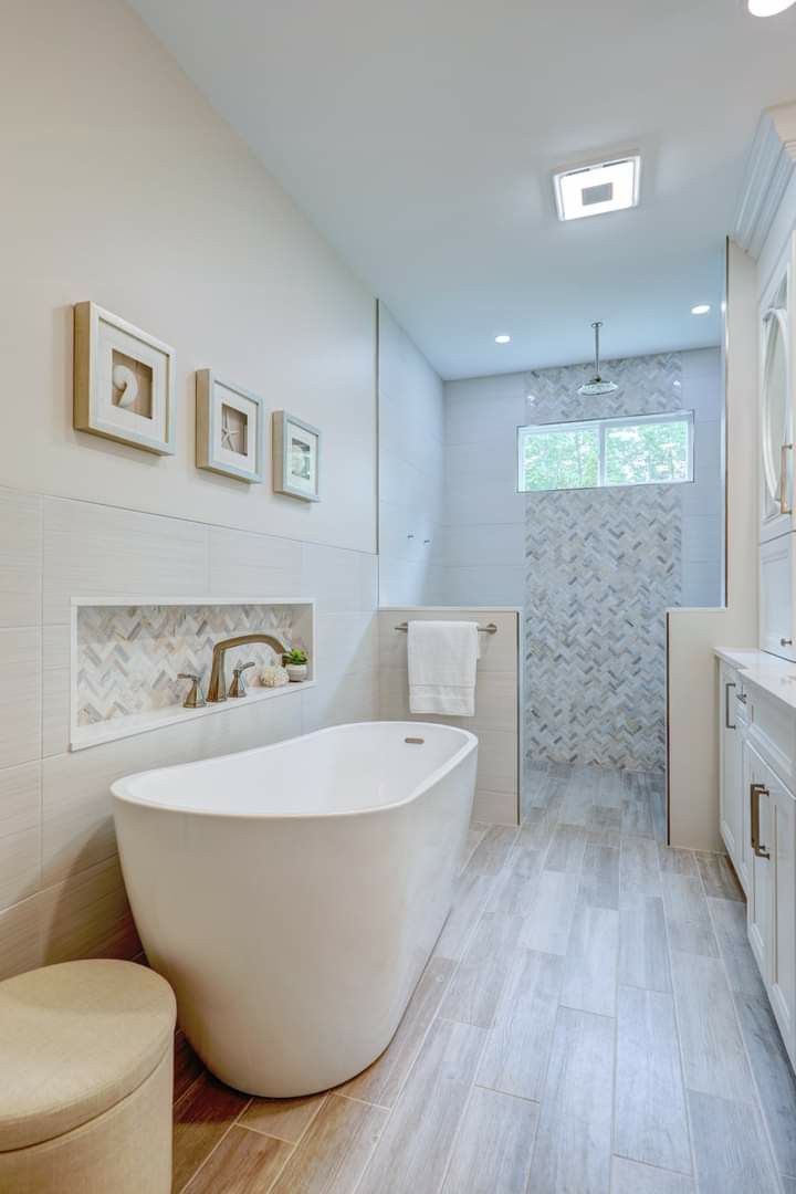 a large white bath tub sitting next to a walk in shower