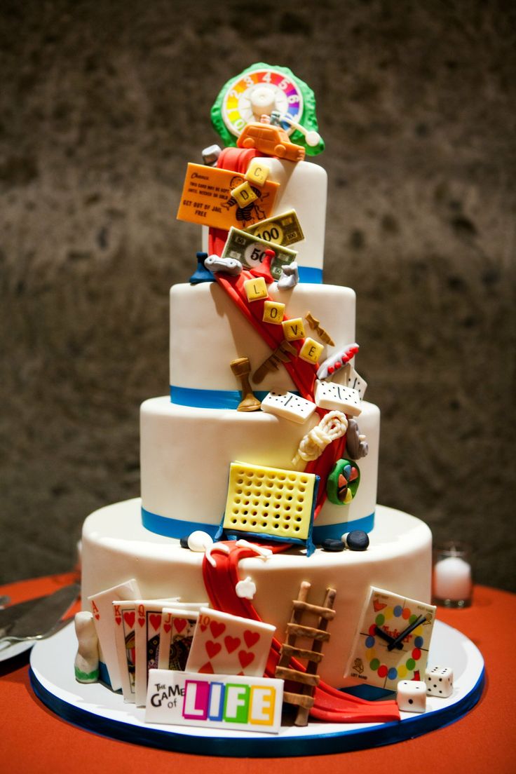 a three tiered cake decorated with cards and magnets on it's side