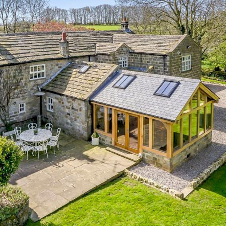 an aerial view of a house with a patio and dining table in the foreground