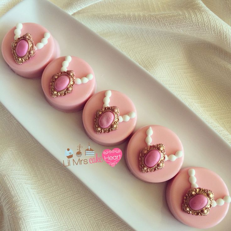 pink and gold decorated cupcakes on a white plate