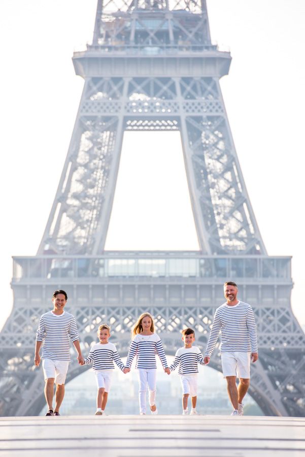 a family walking in front of the eiffel tower