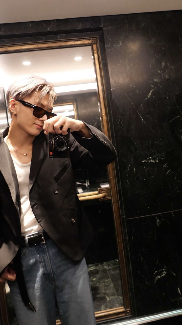 a young man taking a selfie in front of a mirror with his sunglasses on