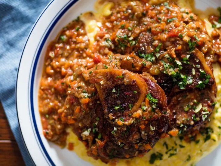 a white plate topped with meat covered in sauce