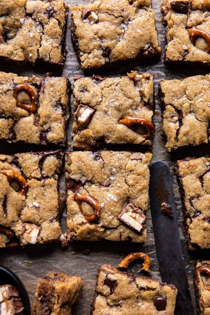 chocolate chip cookie bars cut into squares and sitting on a cutting board with a knife