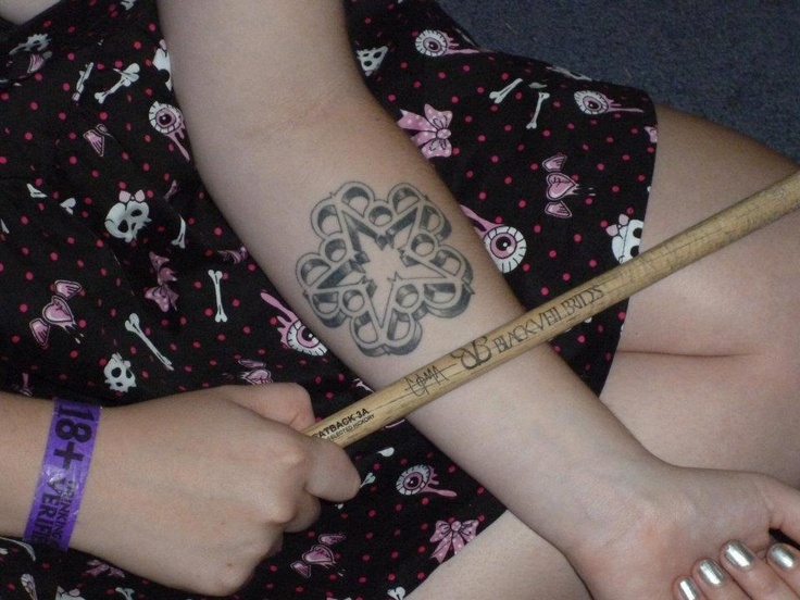 a woman with a tattoo on her arm holding a pencil