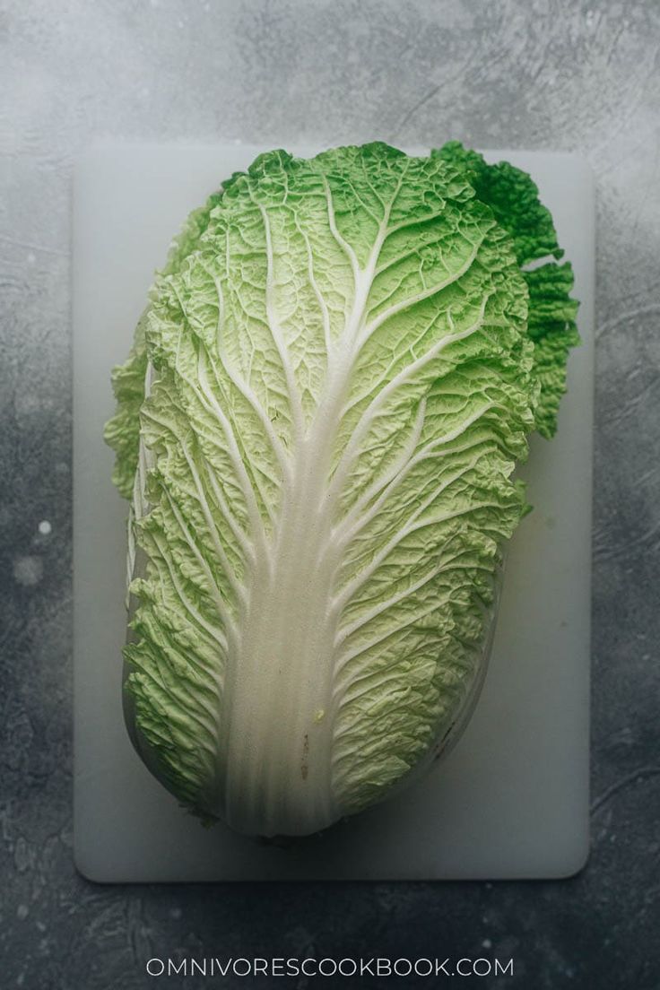 a head of lettuce on a cutting board