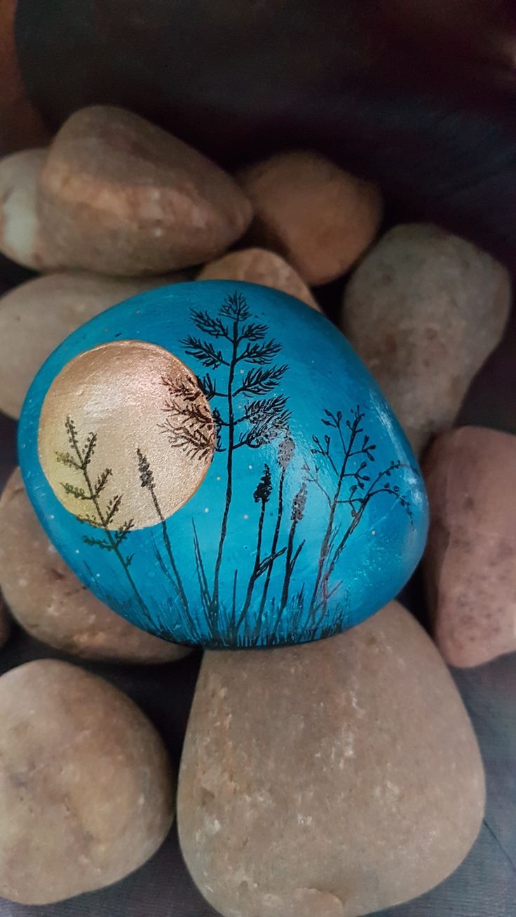 a painted rock sitting on top of some rocks