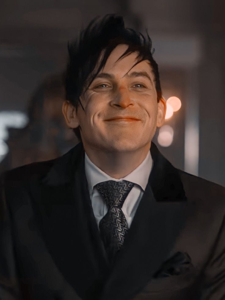 a man in a suit and tie smiling at the camera