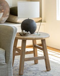 a small table with a lamp on it next to a couch and chair in a living room