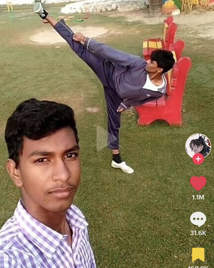 a man standing on one leg in the air doing a handstand with another person sitting behind him