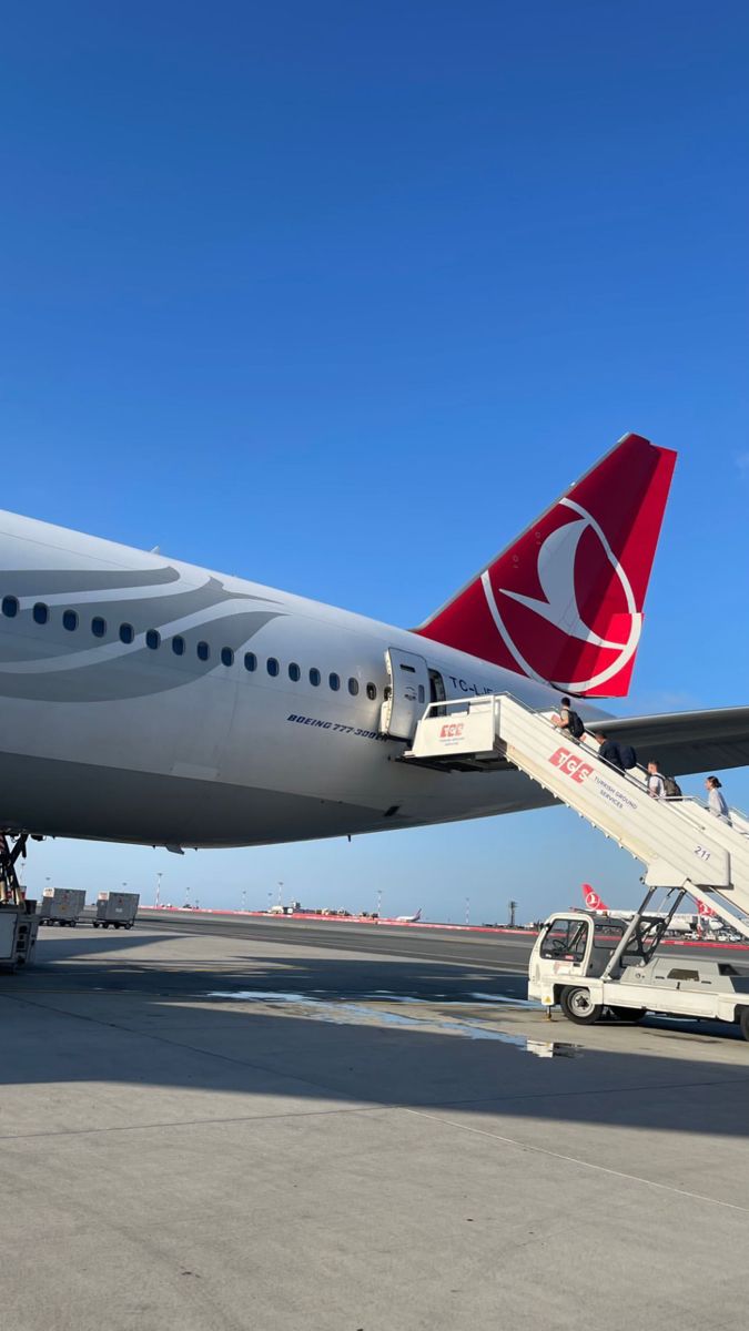 a large jetliner sitting on top of an airport tarmac next to a white truck