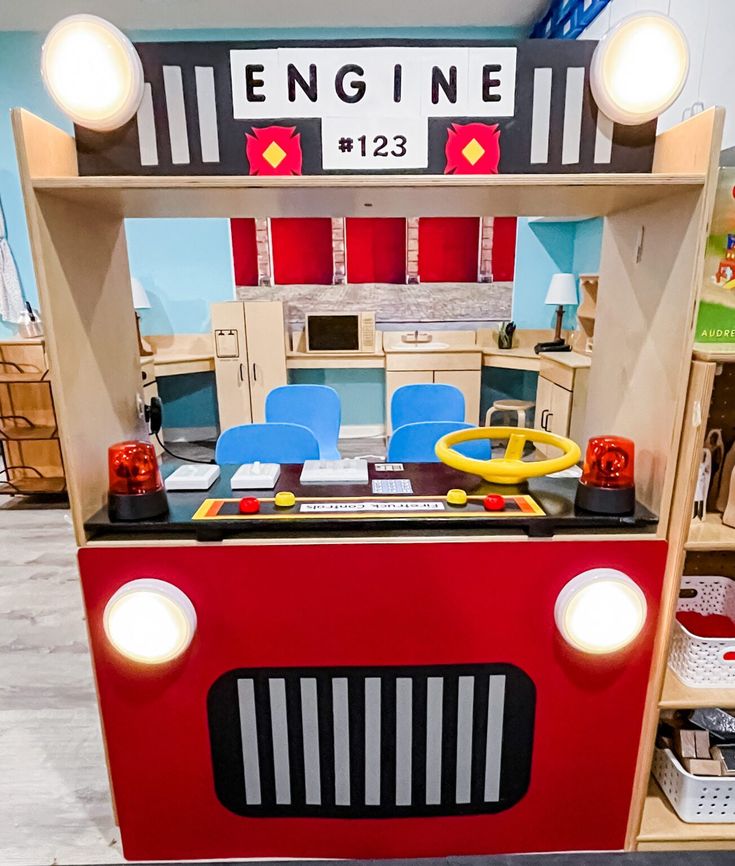 a toy firetruck with lights on it's head is in a playroom