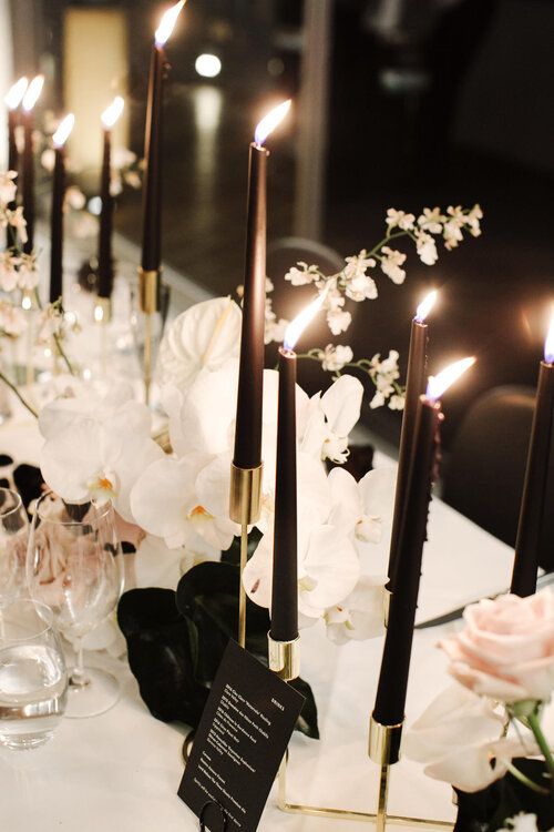 a table topped with lots of white flowers and candles