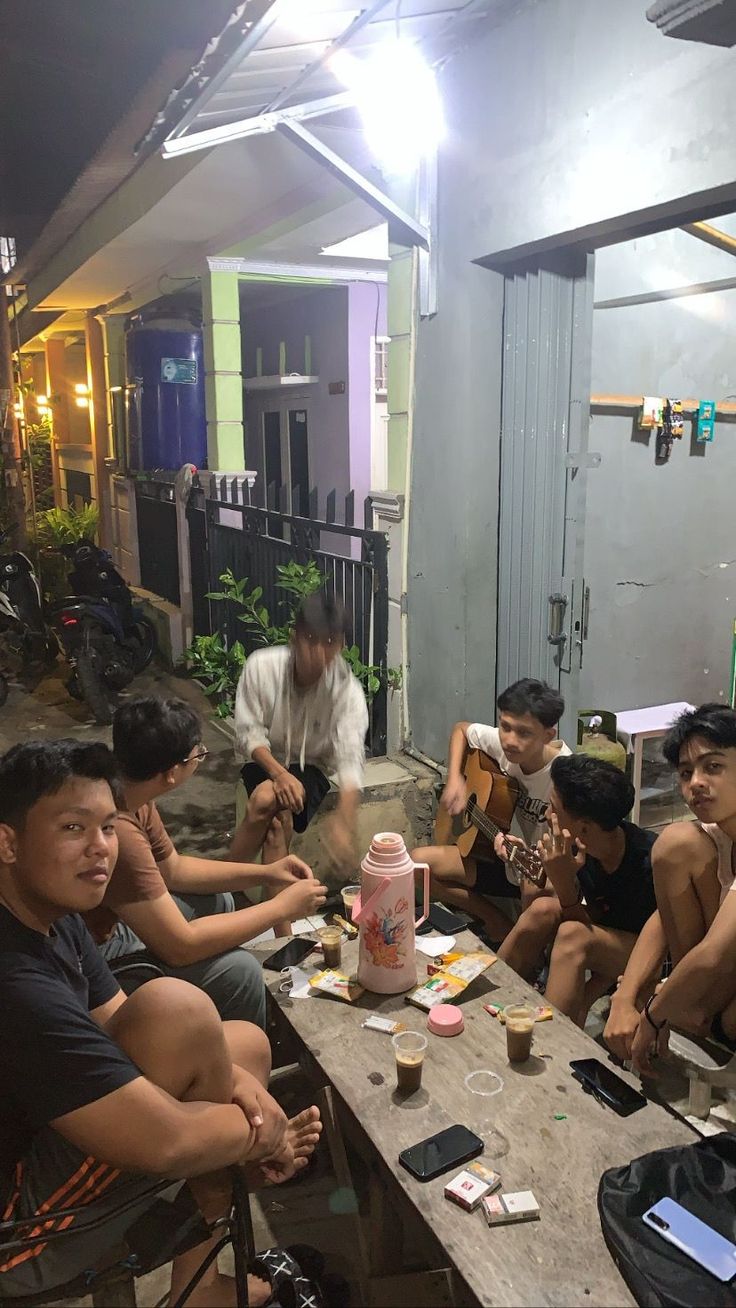 a group of men sitting around a table with food and drinks in front of them