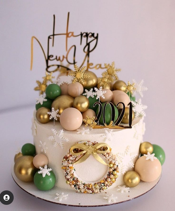 a white cake with gold and green decorations