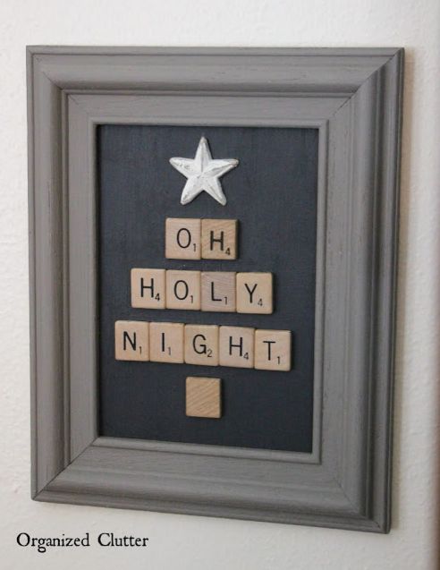 a scrabble tile christmas tree is displayed in a gray frame on the wall