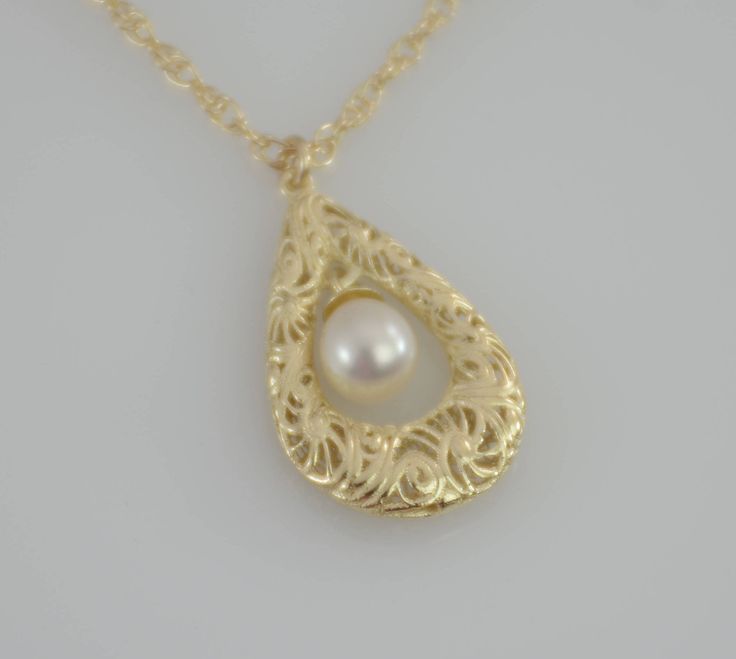 "Filigree necklace - this necklace is adorned with a 14K gold filigree teardrop pendant. A pearl accents the center of the pendant. One side of the pendant is detailed and the other is smooth. Can be worn both ways. Simply stunning. The necklace will be shipped in a beautiful gift box. ★ Filigree teardrop is 14k solid gold, it is 3/4\" x 1/2\". ★ 5 x 6.7mm freshwater cultured pearl ★ The necklace is 14K yellow gold . Please choose 1.5mm flat cable chain (delicate ) or 1.3mm Double rope chain. Pl Elegant Teardrop Drop Necklace With Pearl Charm, Wedding Filigree Teardrop Necklace, Formal Yellow Gold Drop Necklace With Pearl Pendant, Gold Teardrop Pearl Necklace, Yellow Gold Teardrop Necklace With Pearl Pendant, Gold Teardrop Pendant Necklace With Pearl Charm, Filigree Drop Jewelry For Anniversary, Ornate Teardrop Necklace For Gift, Formal Delicate Teardrop Necklace