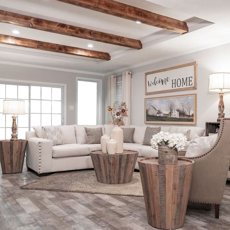 a living room with white couches and wooden beams on the ceiling is decorated in neutral tones