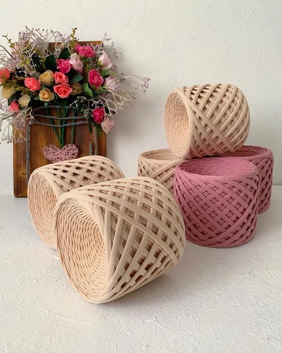 three wicker baskets sitting on top of a white table next to a vase filled with flowers