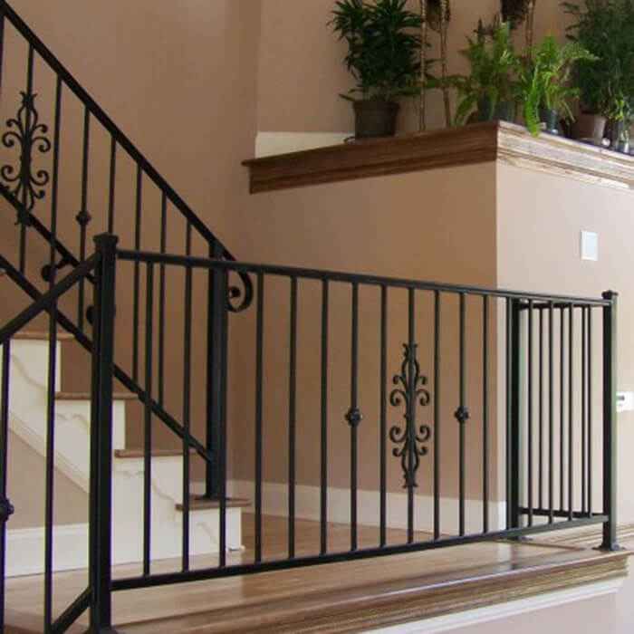 an iron stair railing with potted plants on the top and bottom handrails