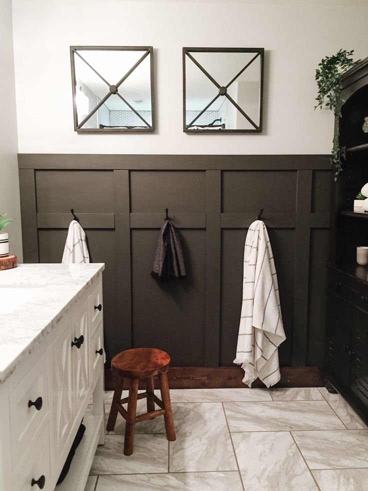 a bathroom with two mirrors on the wall and a stool in front of an open door