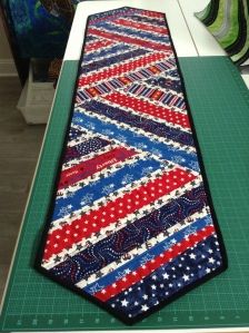 a tie that is laying on top of a green cutting board with polka dots and stripes