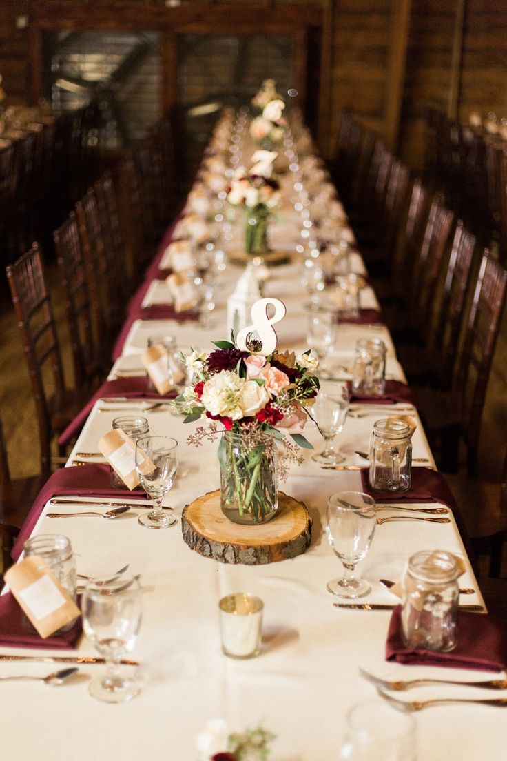 a long table is set with white and red flowers