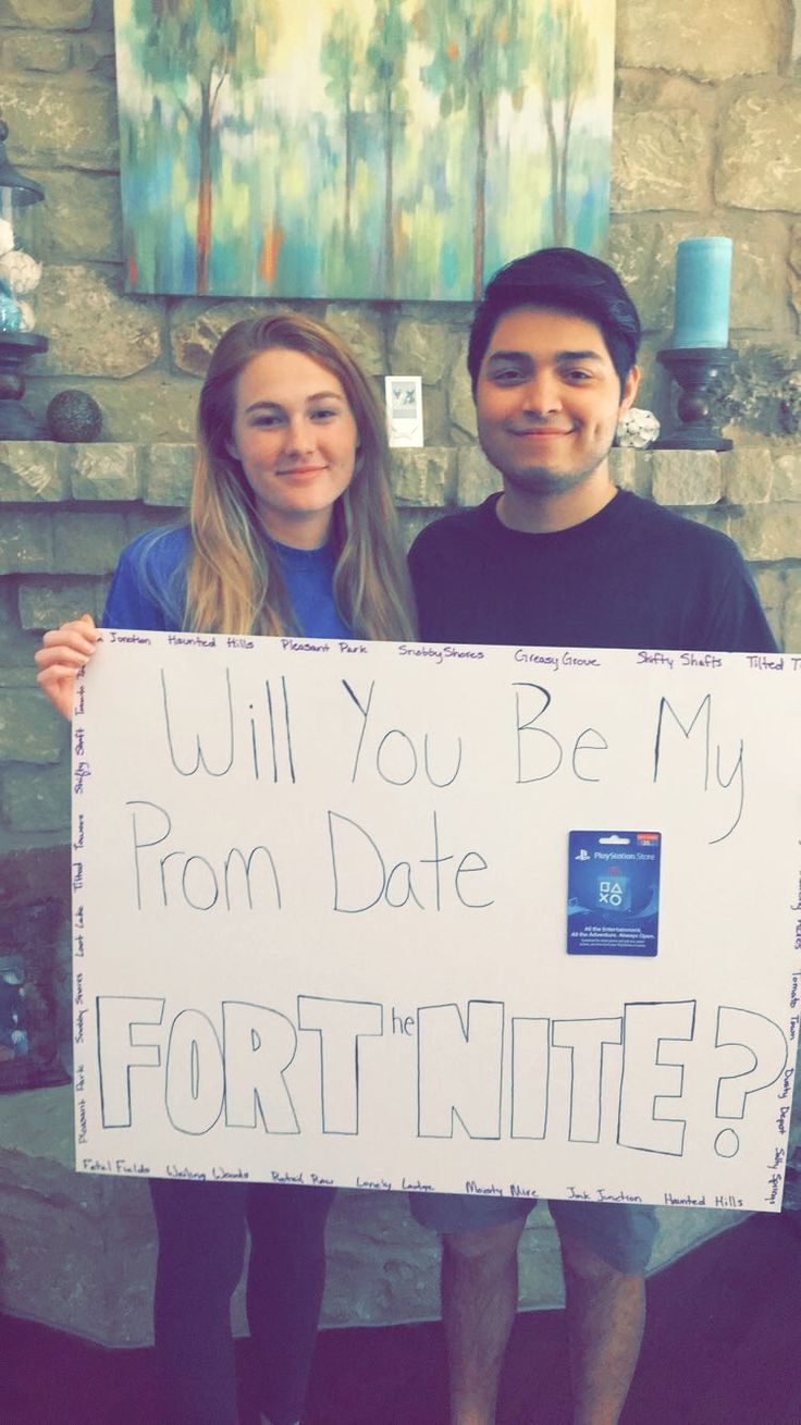 two people holding up a sign that says will you be my from date fortnites?