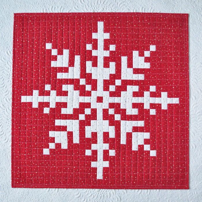 a red and white snowflake quilted onto a wall