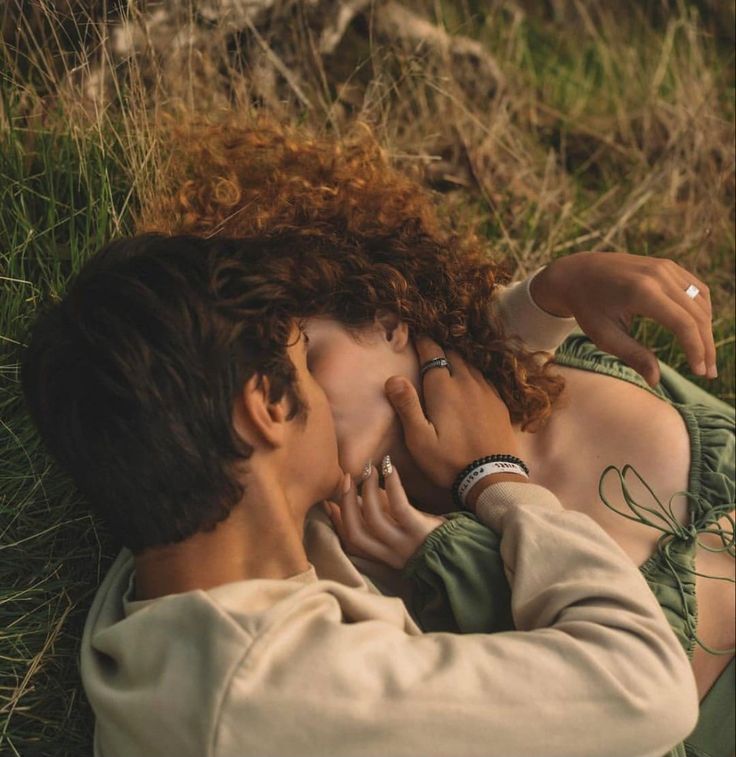 a woman laying on the ground next to a man with red hair and wearing a ring